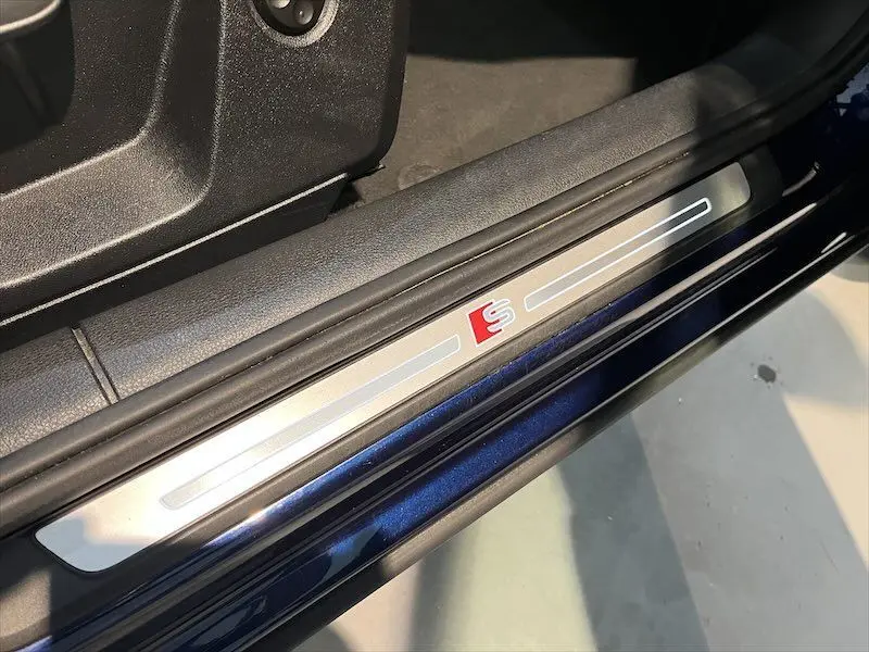 Seuil de porte côté conducteur bleu Navarre métal d'Audi Q2 30 TFSI S-Line avec logo S rouge visible.