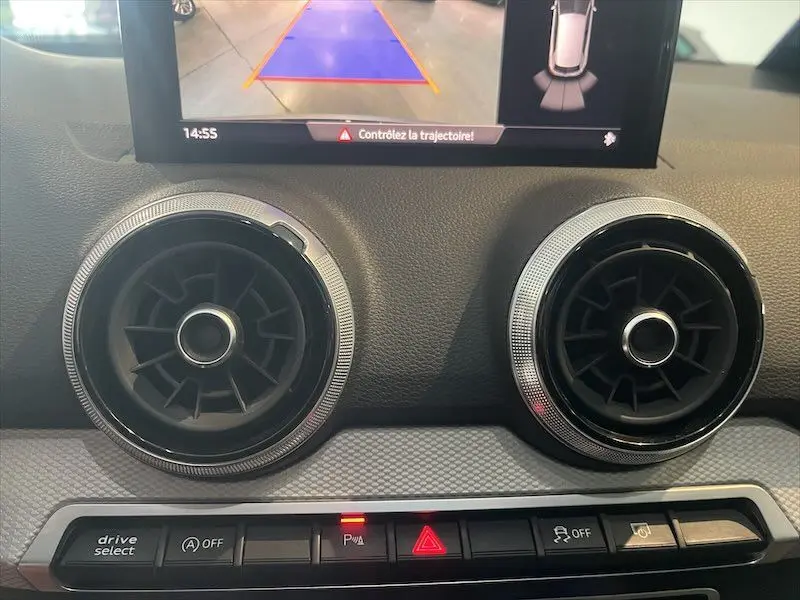 Détail intérieur des aérateurs ronds et commandes sur tableau de bord d'un Audi Q2 Bleu Navarre 2021 S-Line.