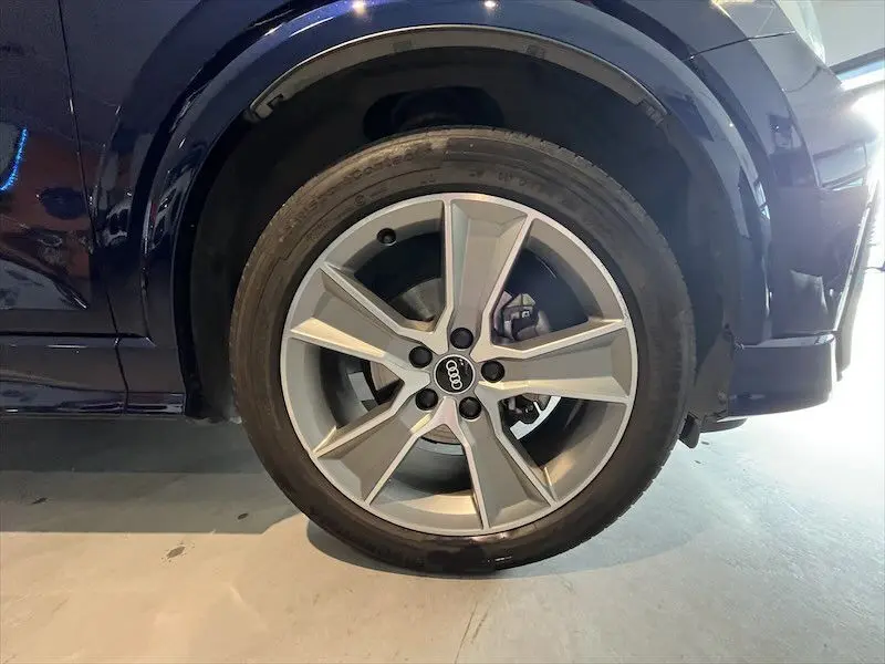 Gros plan sur la roue avant droite de l'Audi Q2 Bleu Navarre Métal 30 TFSI S-Line avec jante alliage distinctive.