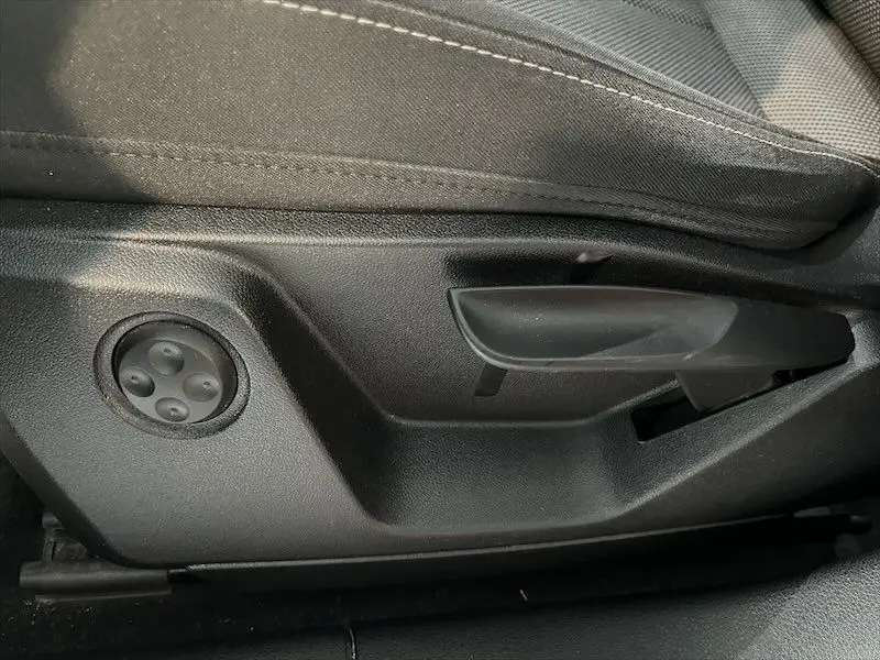 Détail de la commande de réglage manuel du siège conducteur noir dans l'Audi Q2 S-Line 2021 bleu Navarre.