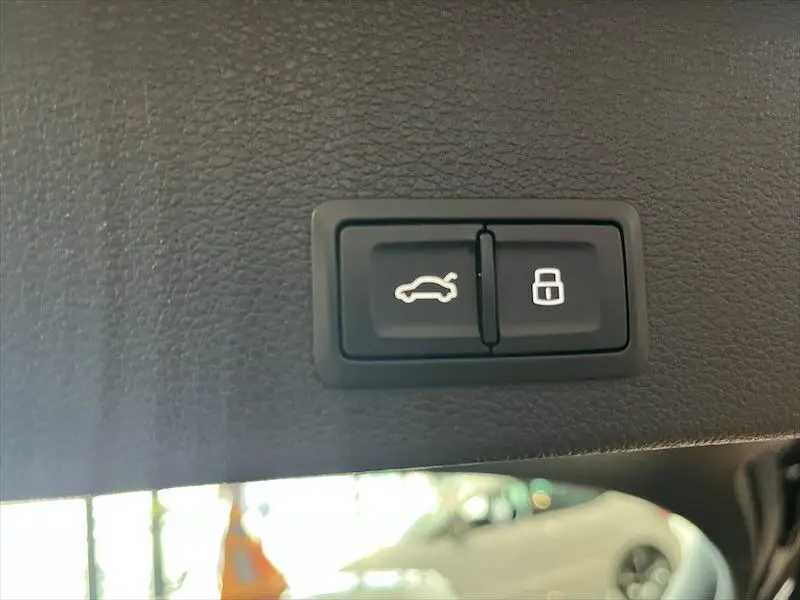 Boutons d'ouverture du coffre et de verrouillage sur le panneau intérieur d'un Audi Q2 bleu Navarre métal 2021.