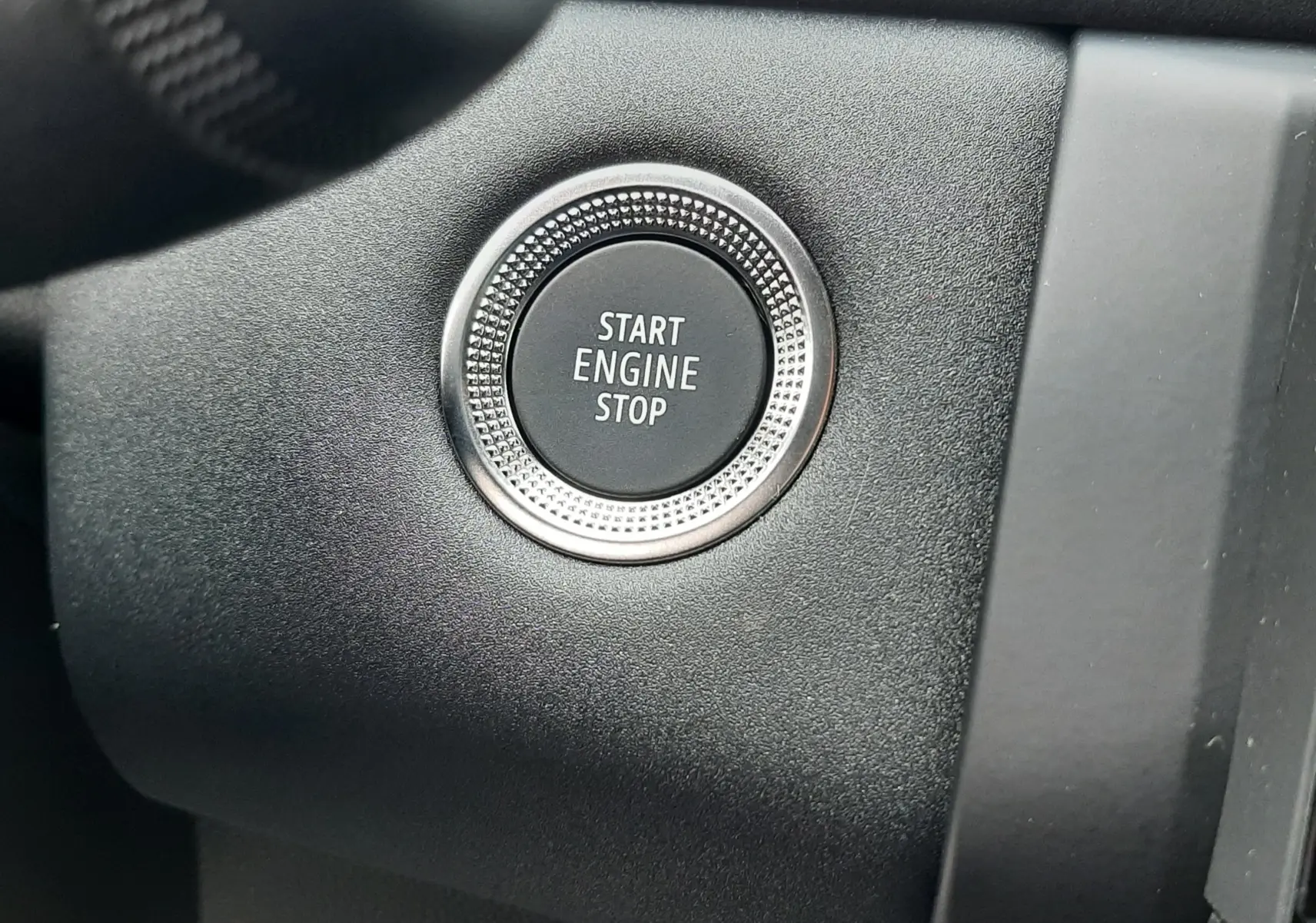 Gros plan sur le bouton Start Engine Stop dans l'habitacle noir du Renault Symbioz blanc nacré 2025.