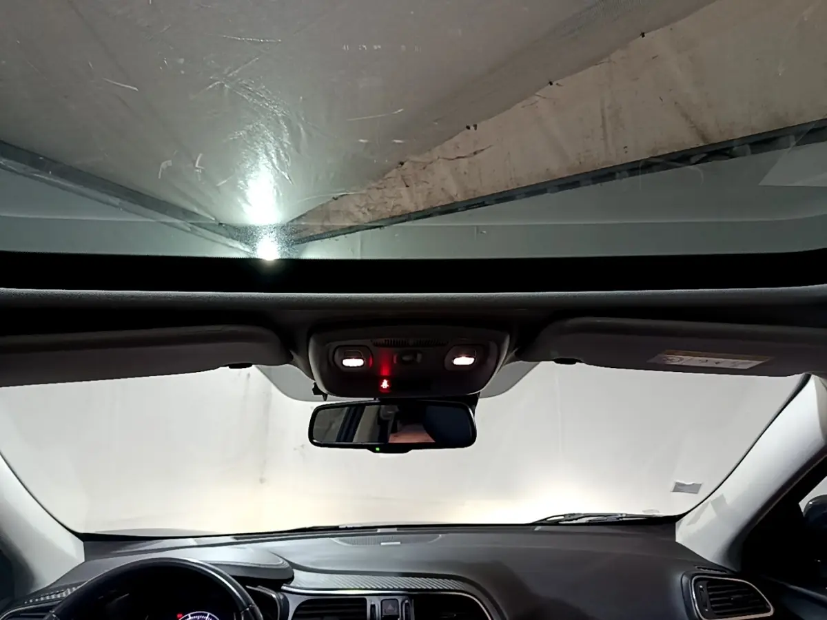 Vue intérieure avant du Renault Kadjar noir 2018, montrant le tableau de bord et le rétroviseur central avec plafonnier allumé.