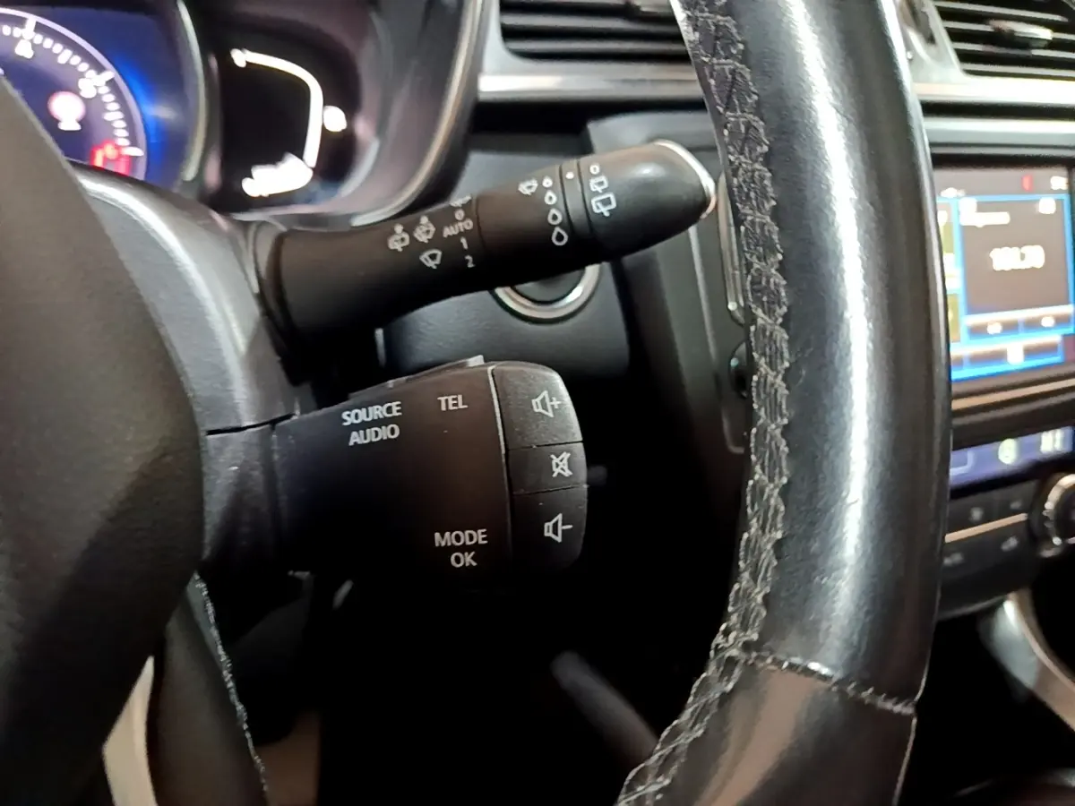 Gros plan sur les commandes audio au volant cuir noir du Renault Kadjar Intens 2018 avec tableau de bord et écran tactile.