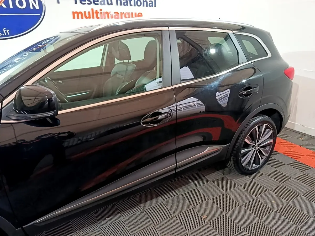 Profil côté gauche du Renault Kadjar Intens noir brillant, mettant en valeur les jantes alliage et les vitres teintées.