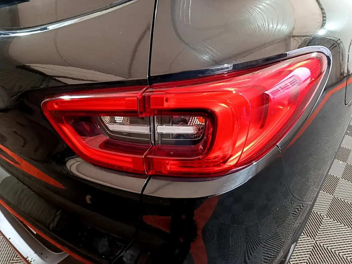 Gros plan sur le feu arrière droit rouge du Renault Kadjar Intens noir, soulignant la carrosserie brillante et les lignes arrière.