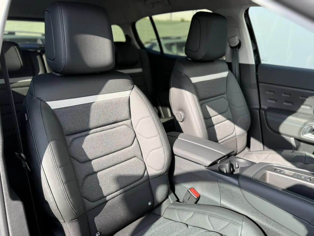 Vue intérieure de face des sièges avant gris foncé du Citroën C5 Aircross 2025 avec accoudoir central et console entre les sièges.