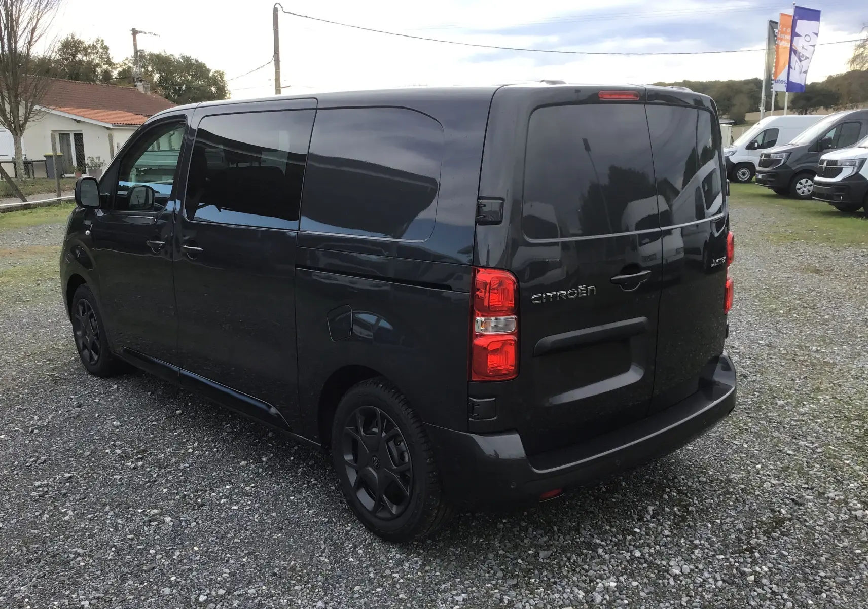 Vue 3/4 arrière droite d'un Citroën Jumpy Cabine Approfondie gris titane avec vitres teintées et feux arrière rouges.
