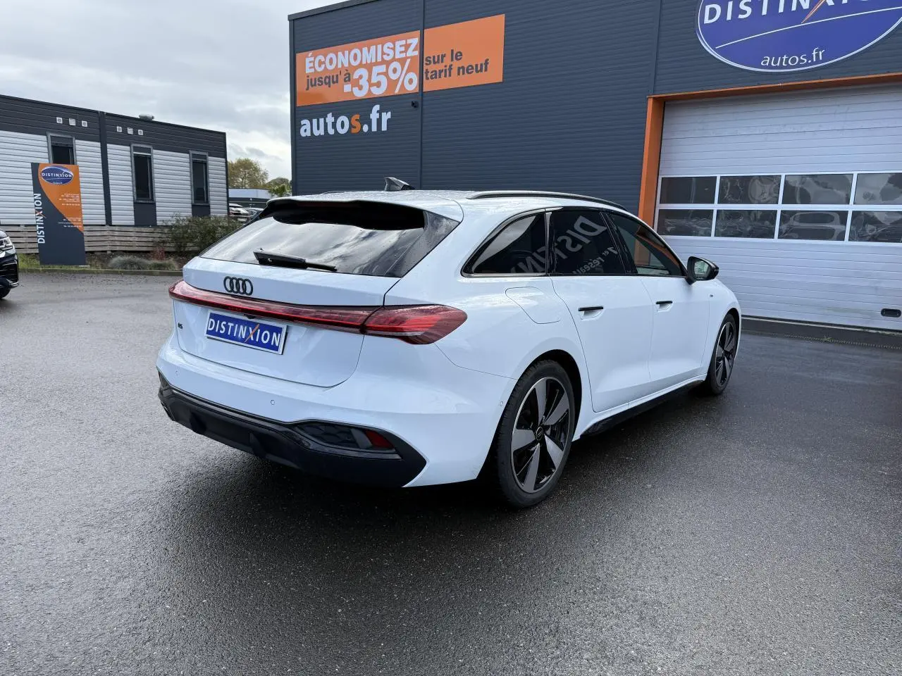 Audi A5 Avant blanc glacier métallisé vue 3/4 arrière droit avec vitres surteintées et jantes noires distinctives