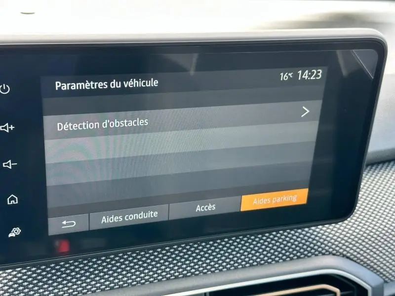 Écran tactile intérieur du tableau de bord de la Dacia Sandero blanc, affichant les paramètres de détection d'obstacles.