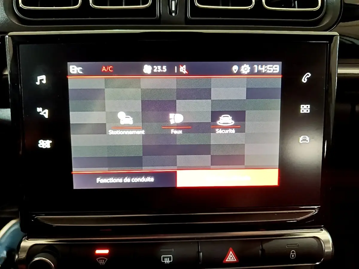Écran tactile central affichant les fonctions de conduite, tableau de bord noir de la Citroën C3 blanche 2023.