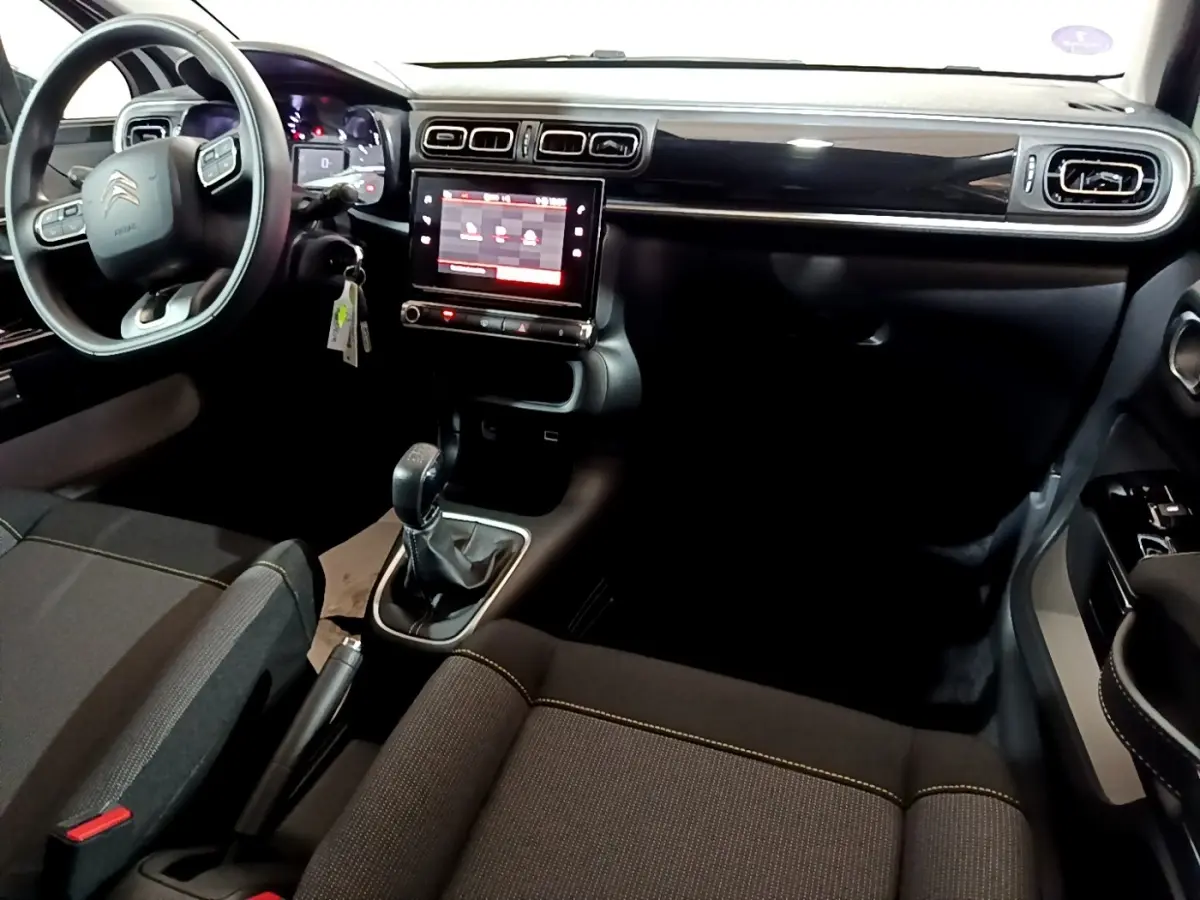 Intérieur noir de la Citroën C3 PureTech 83 Shine 2023, vue du poste de conduite avec écran tactile central.