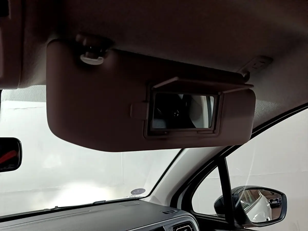 Miroir de courtoisie ouvert côté conducteur dans l'habitacle d'une Citroën C3 blanche 2023.