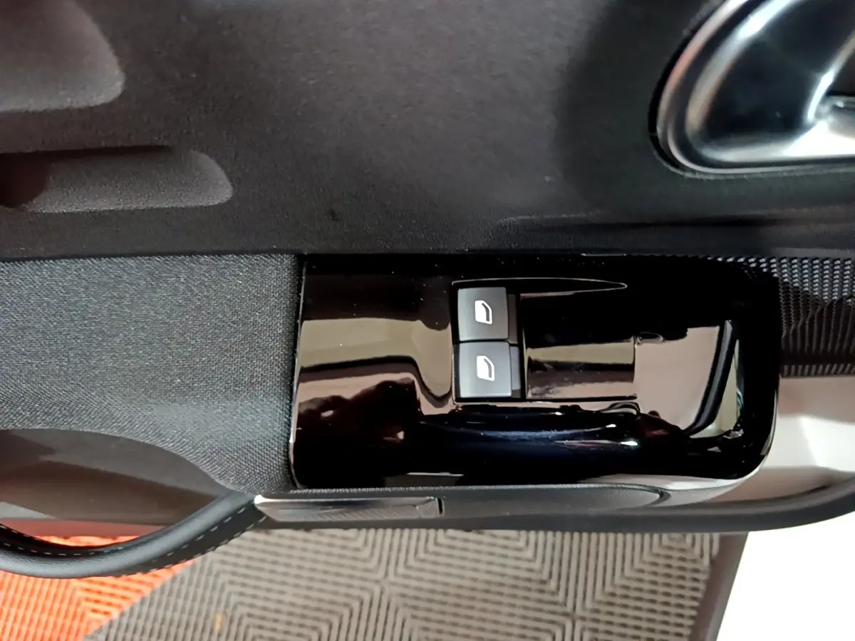 Boutons de commande des vitres électriques sur la porte intérieure côté conducteur d'une Citroën C3 blanche 2023.