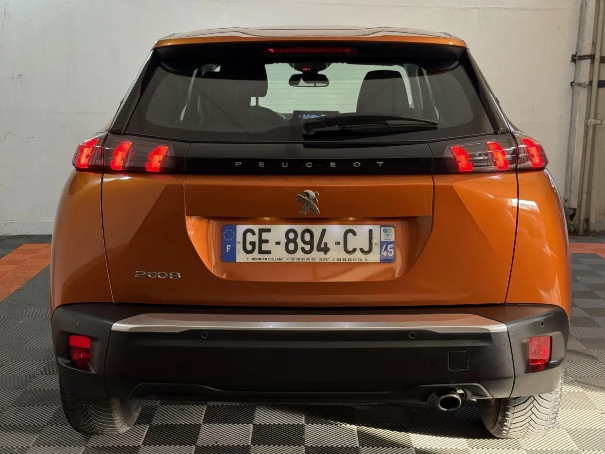 Vue arrière d'un Peugeot 2008 orange 2022 avec feux LED caractéristiques et plaque d'immatriculation française.