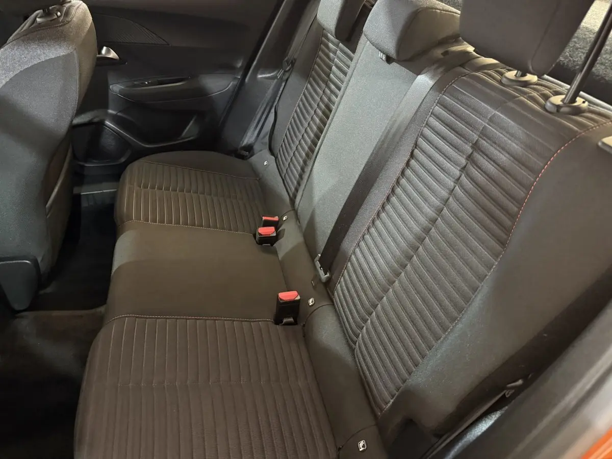 Vue intérieure sur la banquette arrière noire du Peugeot 2008 orange, montrant les sièges avec ceintures et appuie-têtes.