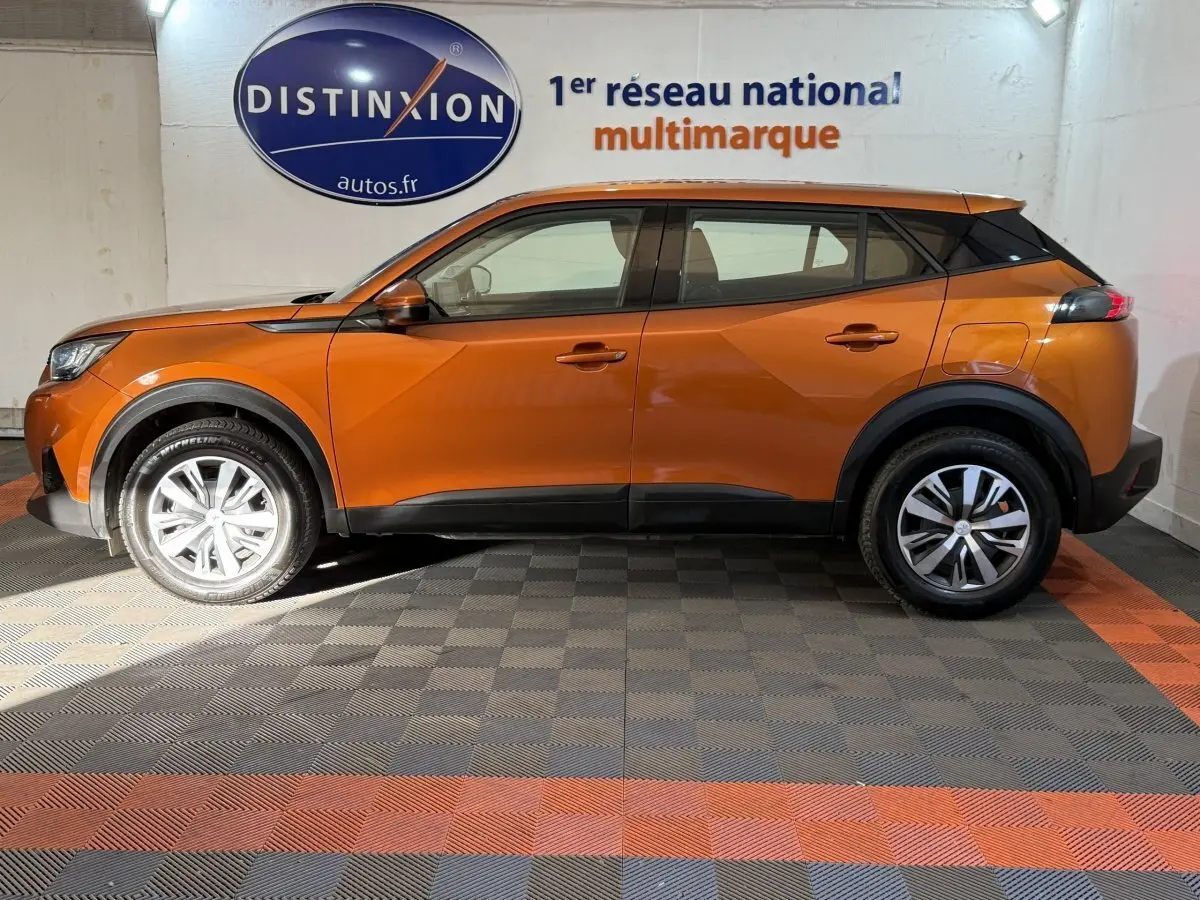 Profil droit d'un Peugeot 2008 orange 2022 avec jantes alliage et détails noirs contrastants sur les bas de caisse.
