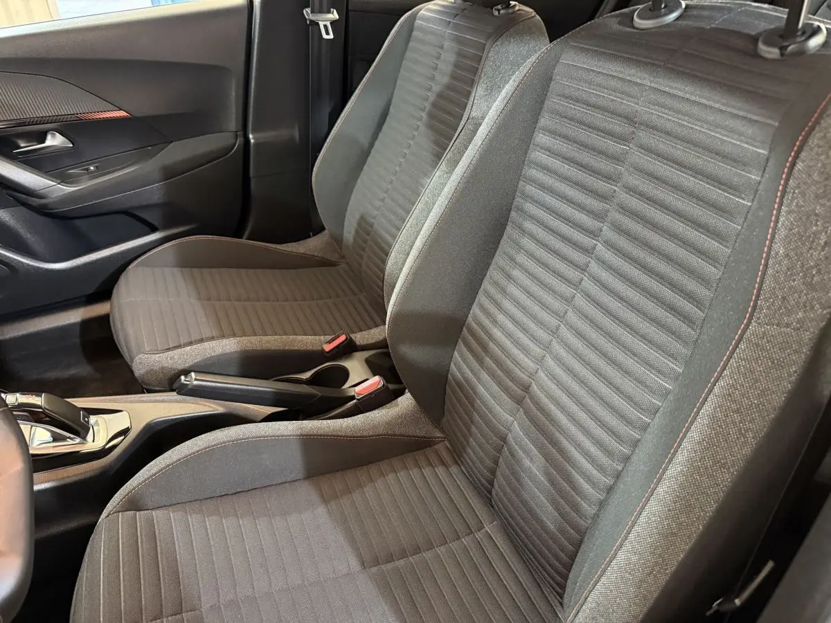 Vue intérieure côté droit des sièges avant gris foncé avec surpiqûres orange dans une Peugeot 2008 2022.