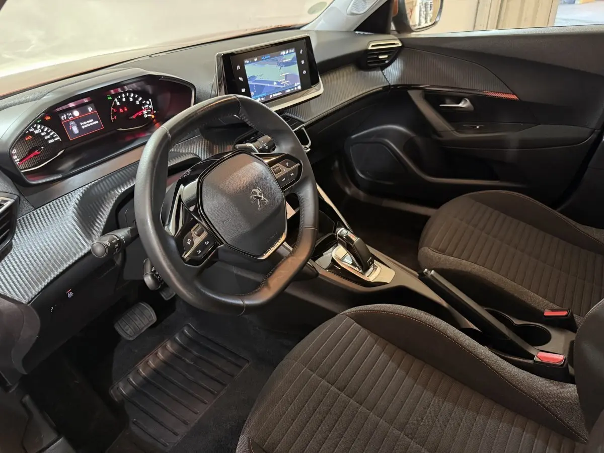 Vue intérieure côté conducteur du Peugeot 2008 2022, tableau de bord avec écran tactile et volant cuir noir.
