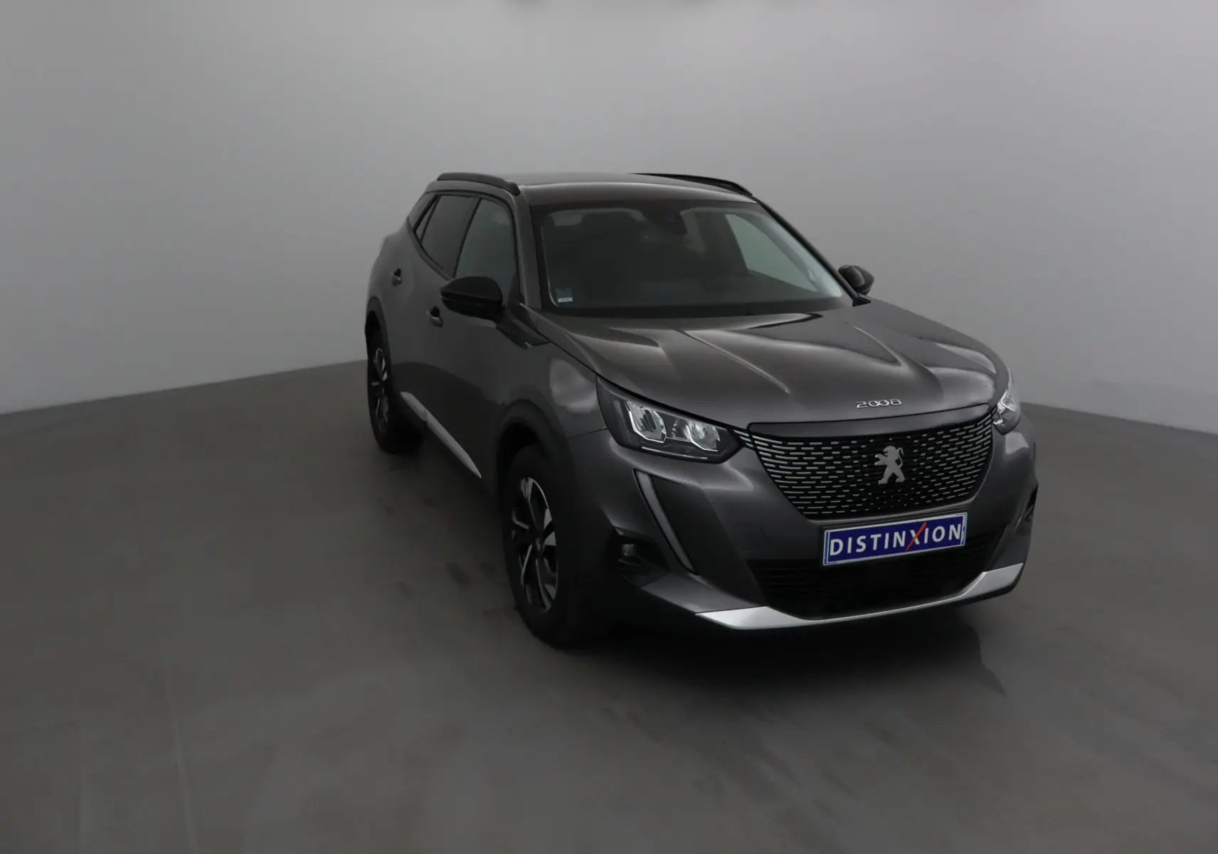Peugeot 2008 gris platinium en vue 3/4 avant droit, avec calandre noire et jantes alliage 17 pouces.