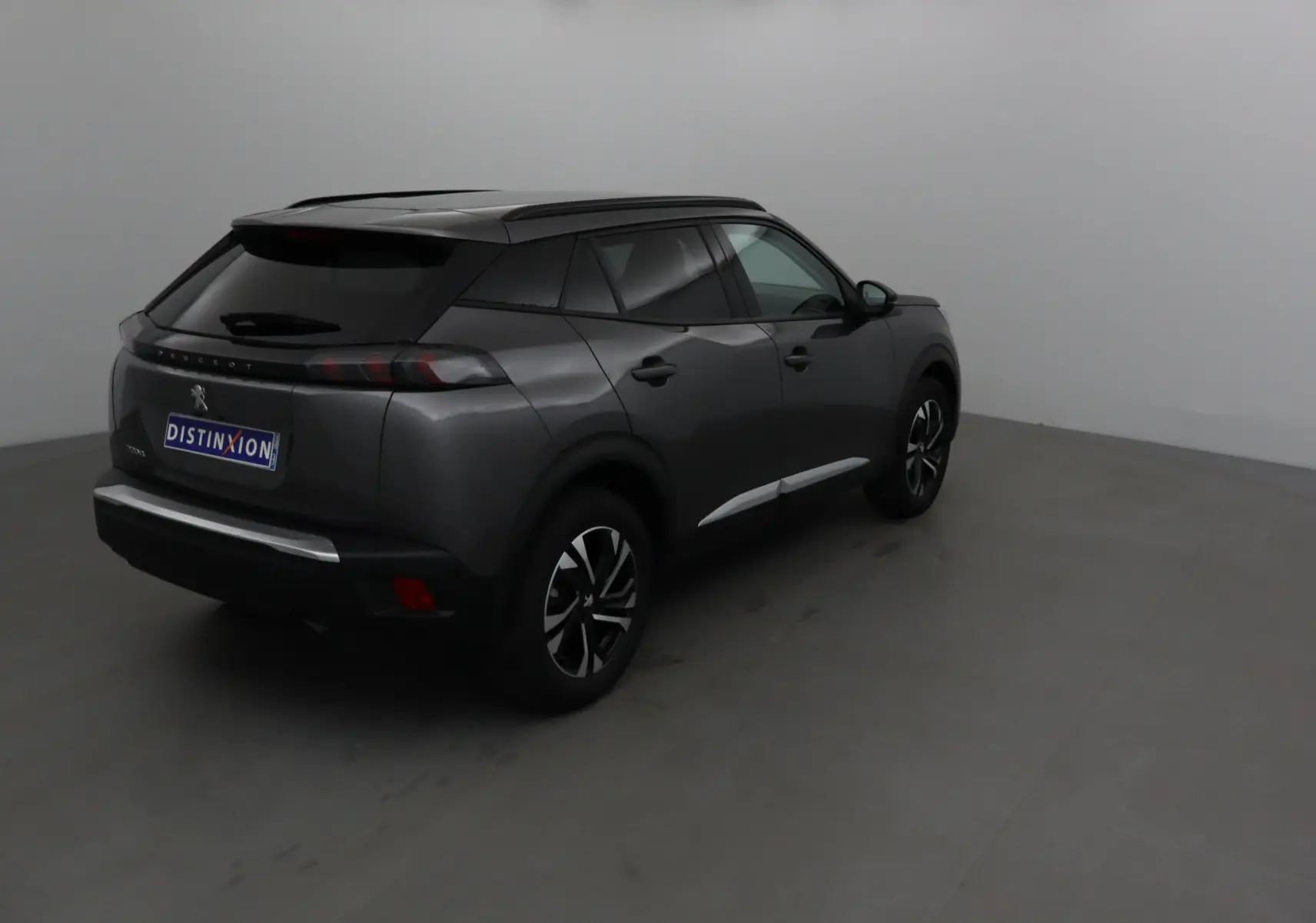 Peugeot 2008 gris platinium vue 3/4 arrière droit, avec jantes alliage noires et toit noir contrasté.