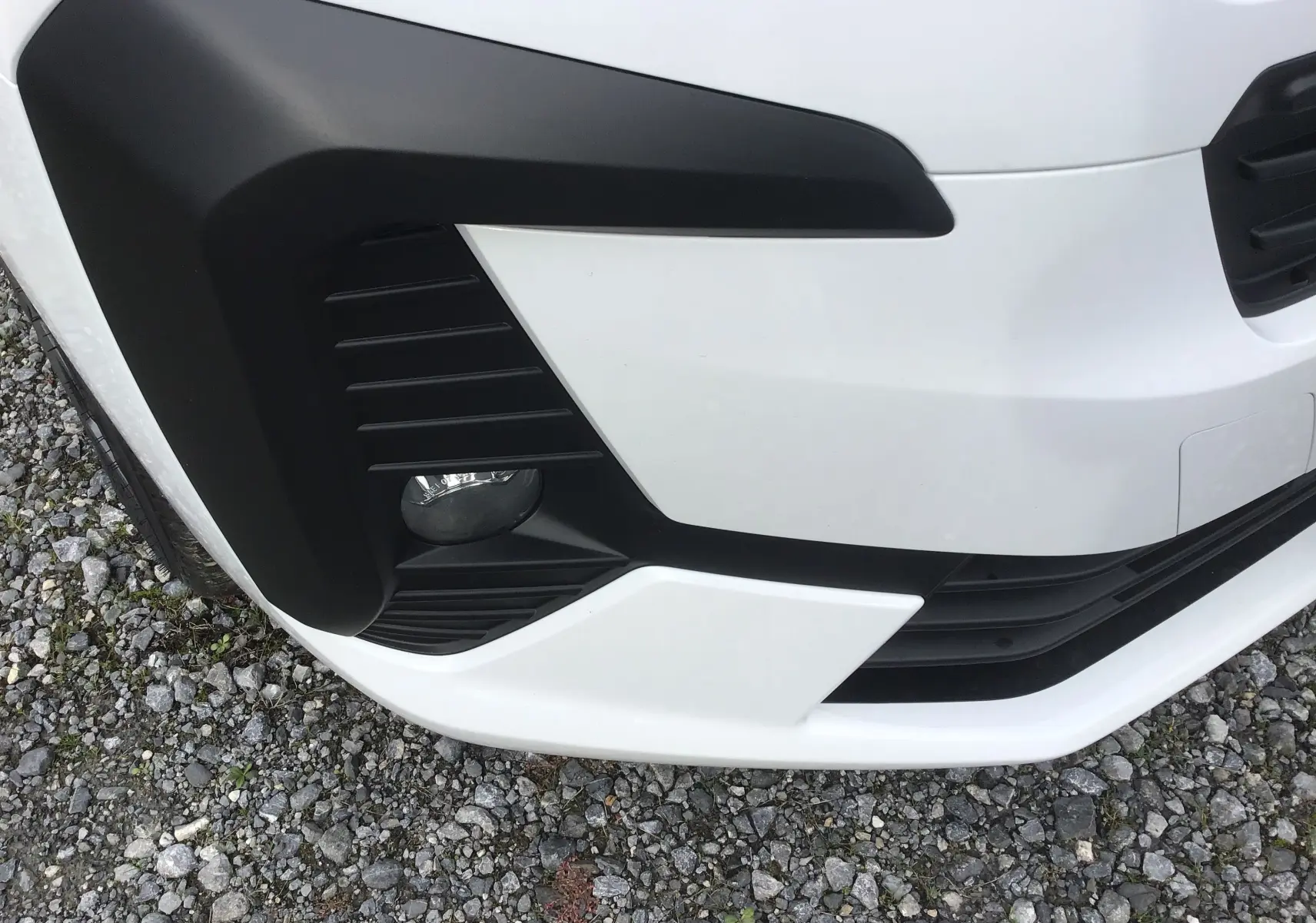 Gros plan sur l'angle avant gauche blanc du Citroën Jumpy avec antibrouillard intégré et détails noirs contrastants.