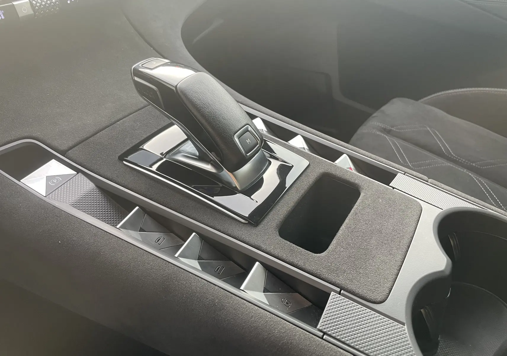 Le levier de vitesse noir et brillant de la DS7 1.5 BlueHDi 130 en vue rapprochée sur la console centrale grise.