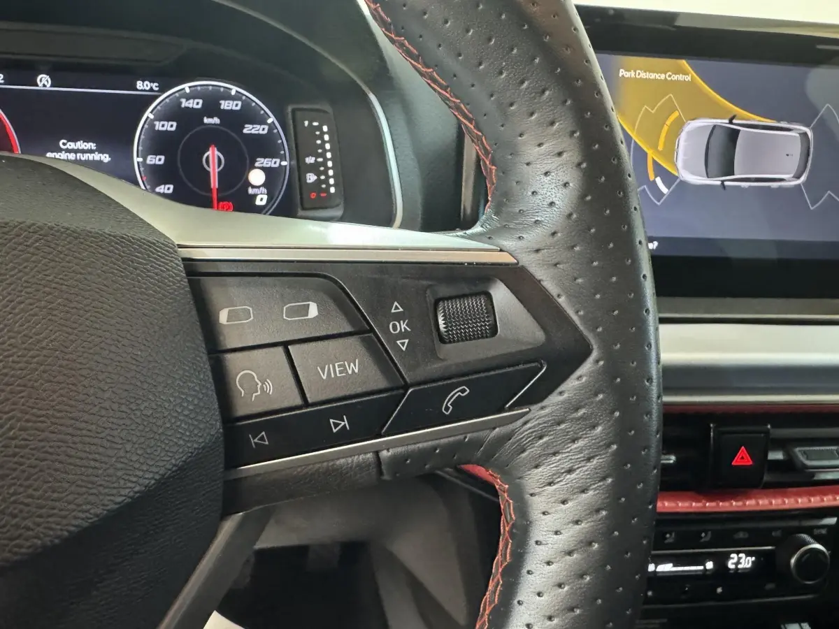 Détail du volant cuir noir avec surpiqûres rouges et tableau de bord digital de la SEAT Ibiza 1.0 TSI 110 FR 2024.