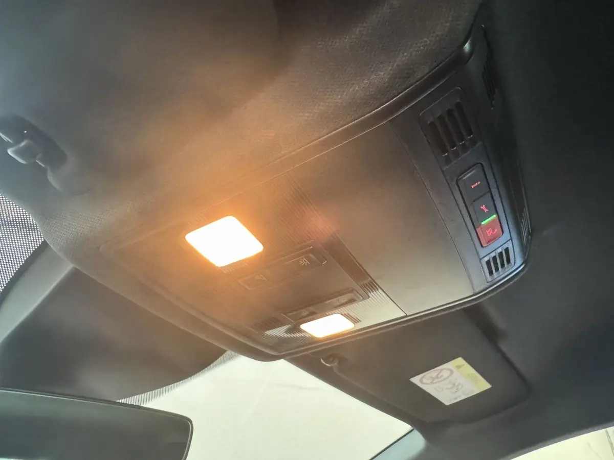 Plafonnier intérieur allumé avec commandes d'appel d'urgence dans un SEAT IBIZA 2024 rouge, vue vers le toit avant.