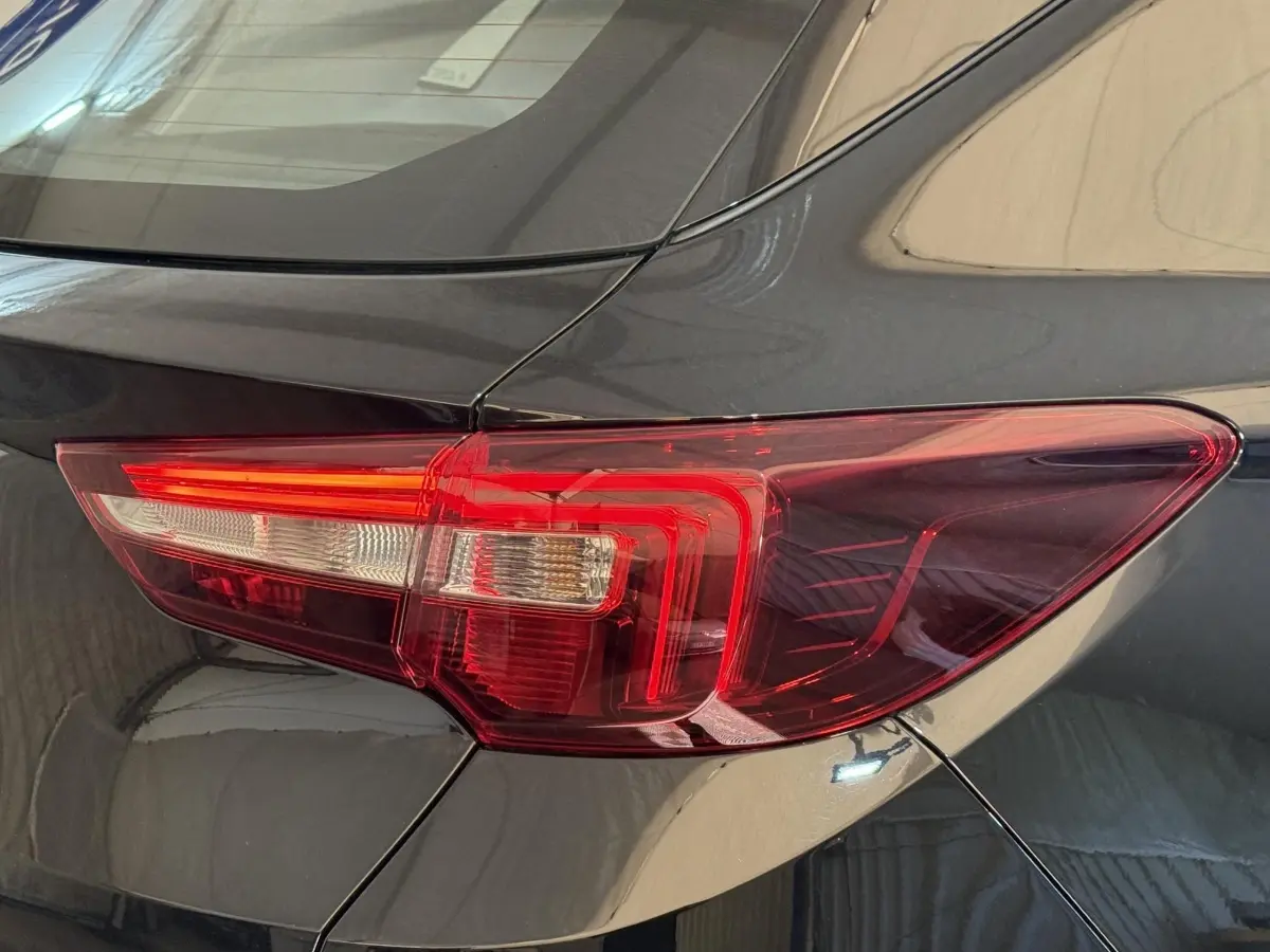 Gros plan sur le feu arrière droit rouge du SUV Opel Grandland X noir, montrant la carrosserie brillante.