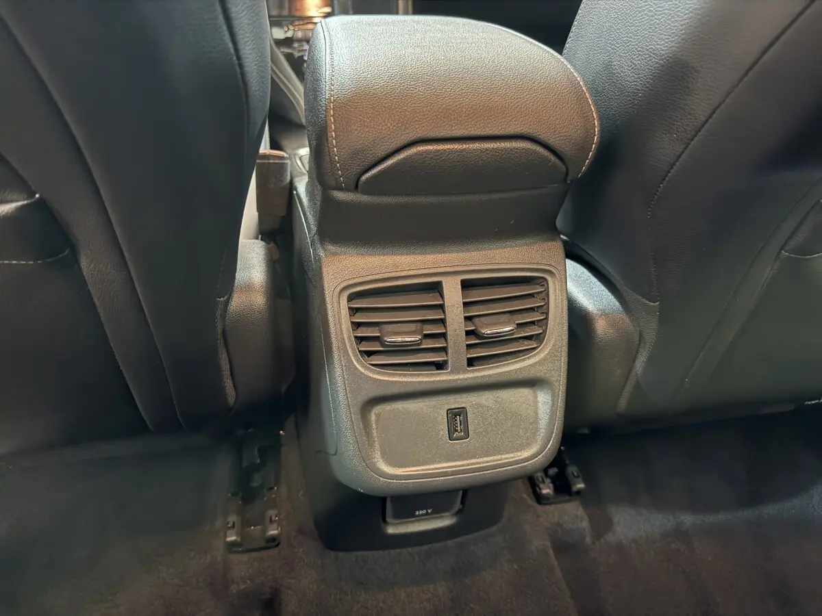 Vue rapprochée des aérateurs arrière et prise USB entre les sièges avant noirs de l'Opel Grandland X noir.