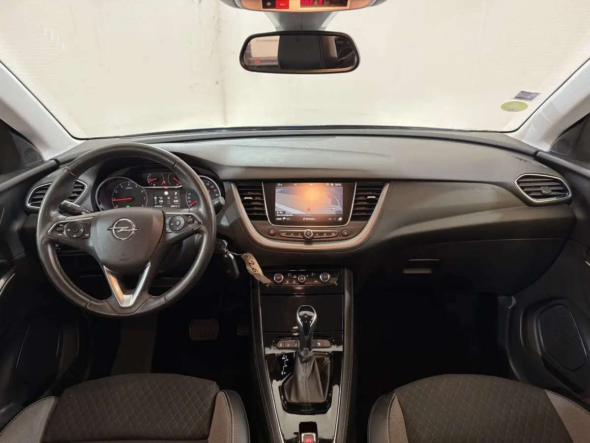 Vue intérieure avant de l’Opel Grandland X 2021, tableau de bord noir avec écran tactile et volant cuir multifonctions.