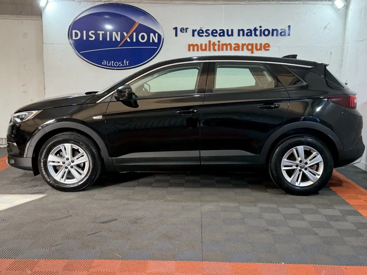 Profil côté gauche d'un Opel Grandland X noir 2021, finition Elegance Business, roues alliage et feux arrière LED.