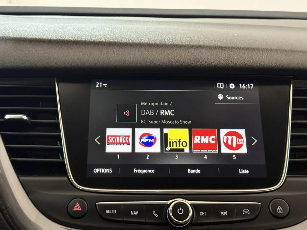 Écran tactile central affichant les stations radio dans l’habitacle d’une Opel Grandland X noir, vue de face.