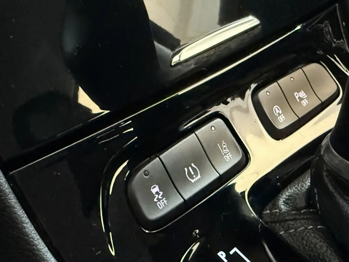Gros plan sur les boutons de commande noirs de l’Opel Grandland X noir, console centrale près du levier de vitesse.