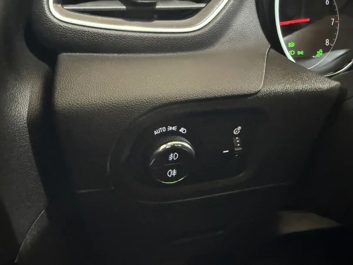 Gros plan sur le bouton de commande des phares et antibrouillards dans l’habitacle noir de l’Opel Grandland X 2021.