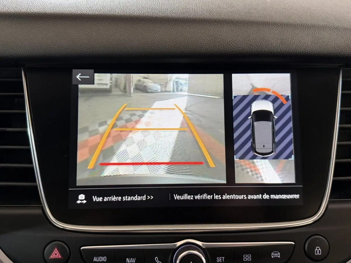 Écran tactile intérieur montrant la caméra de recul et l’aide au stationnement du tableau de bord Opel Grandland X noir.