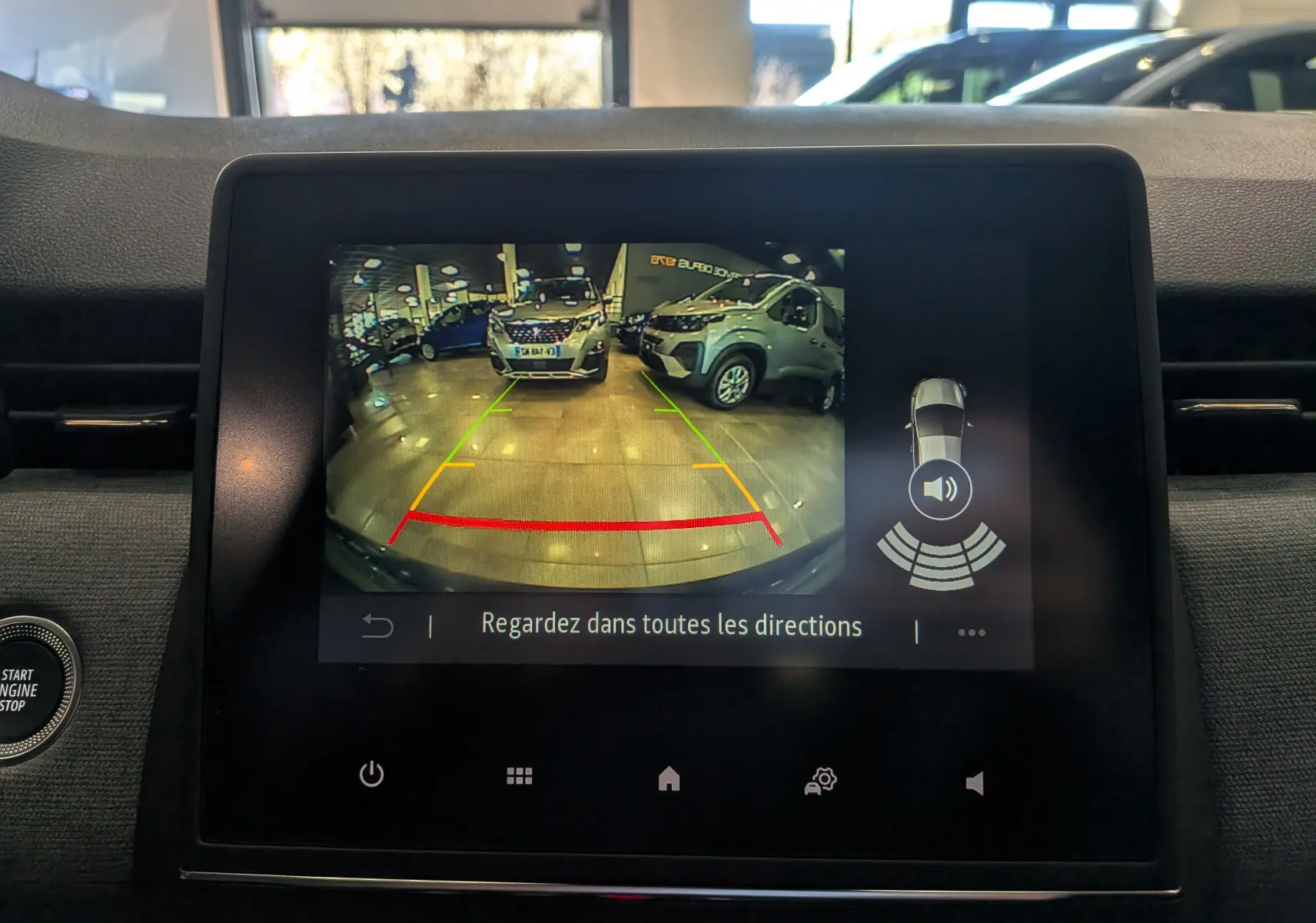 Écran central de la Renault Clio V Bleu Iron montrant la caméra de recul avec guidage de trajectoire en intérieur.