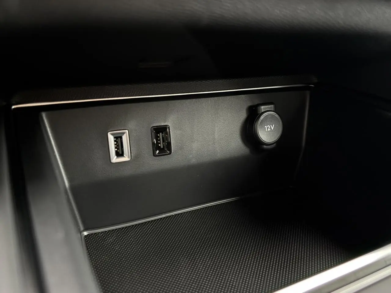Vue rapprochée de la console centrale noire du Citroën C5 Aircross 2025 avec prises USB et prise 12V.