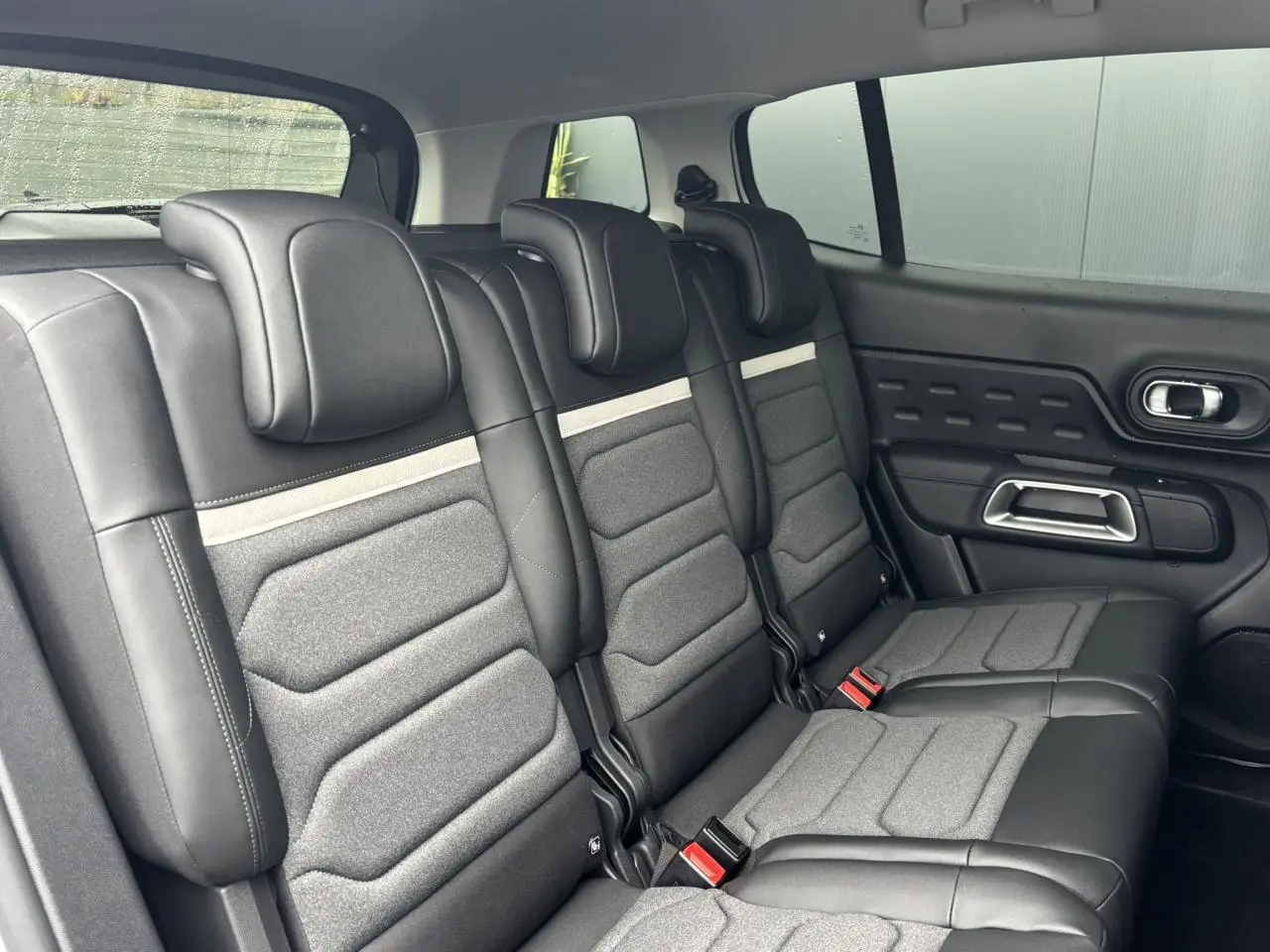 Vue latérale intérieure des trois sièges arrière indépendants en cuir et tissu gris du Citroën C5 Aircross 2025.