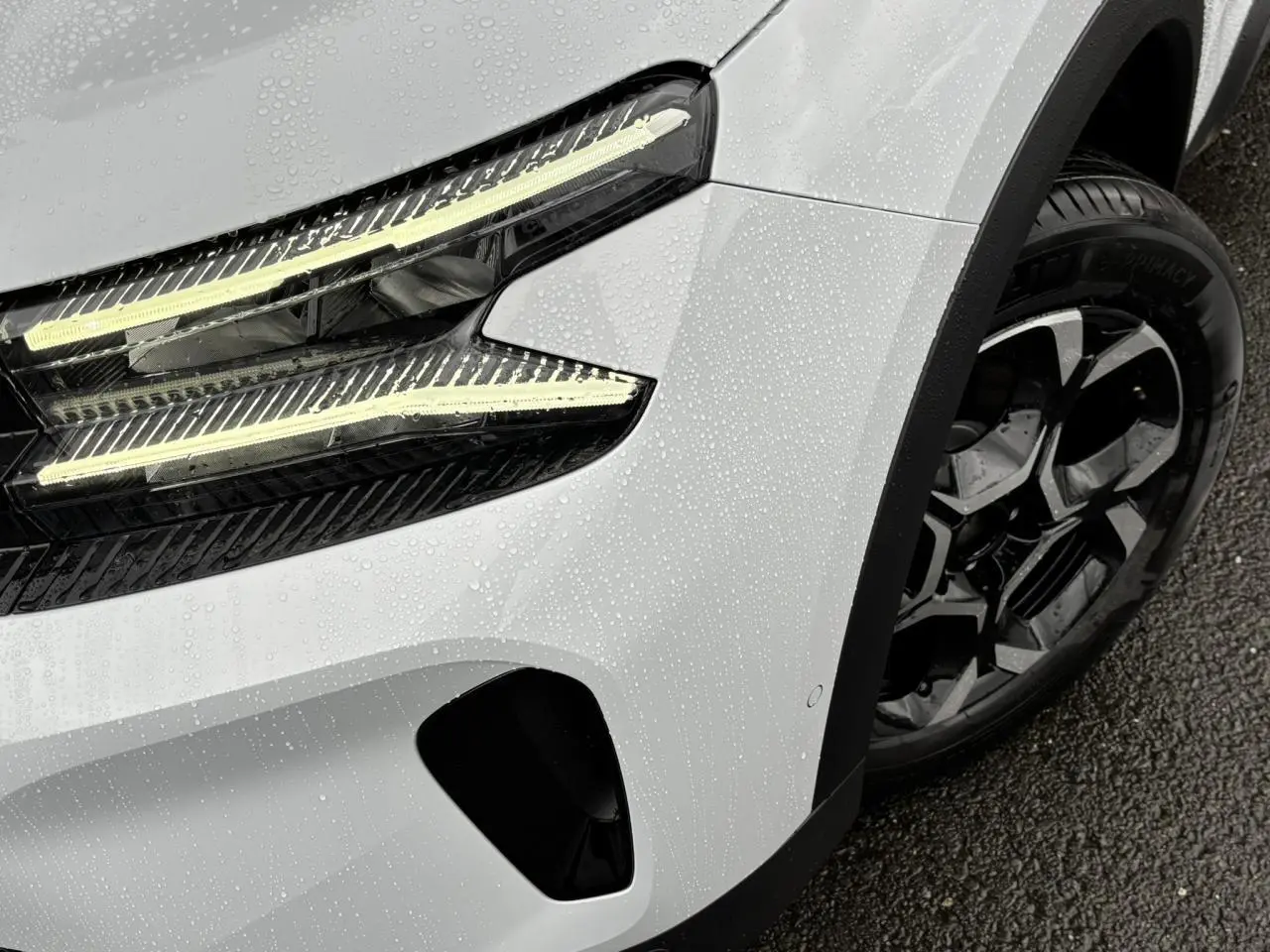 Gros plan sur l'avant droit blanc Okénite du Citroën C5 Aircross 2025 avec phares LED et jante alliage bi-ton.