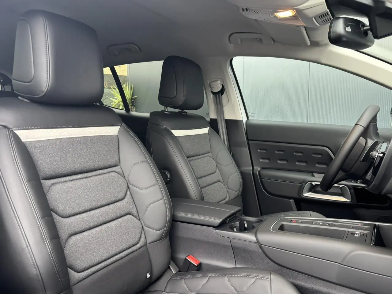 Vue intérieure côté droit des sièges avant en tissu et cuir noir avec surpiqûres claires du Citroën C5 Aircross 2025.