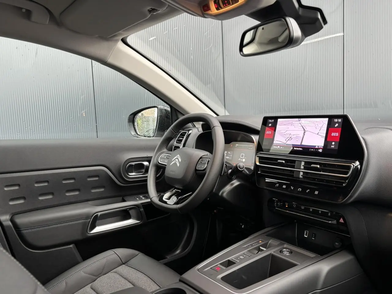 Vue intérieure côté conducteur du Citroën C5 Aircross 2025 avec tableau de bord noir et écran tactile central.