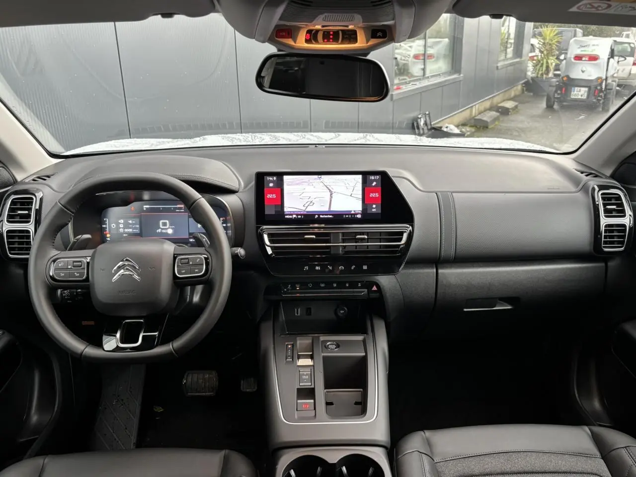 Vue intérieure avant du Citroën C5 Aircross 2025, tableau de bord noir avec écran tactile central et volant multifonction.
