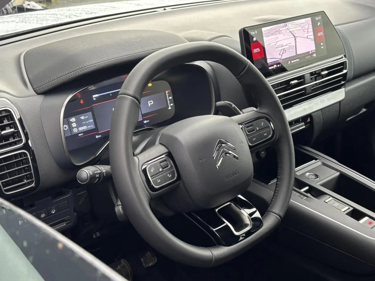 Vue rapprochée du volant et du tableau de bord numérique du Citroën C5 Aircross blanc, avec écran tactile et commandes intégrées.