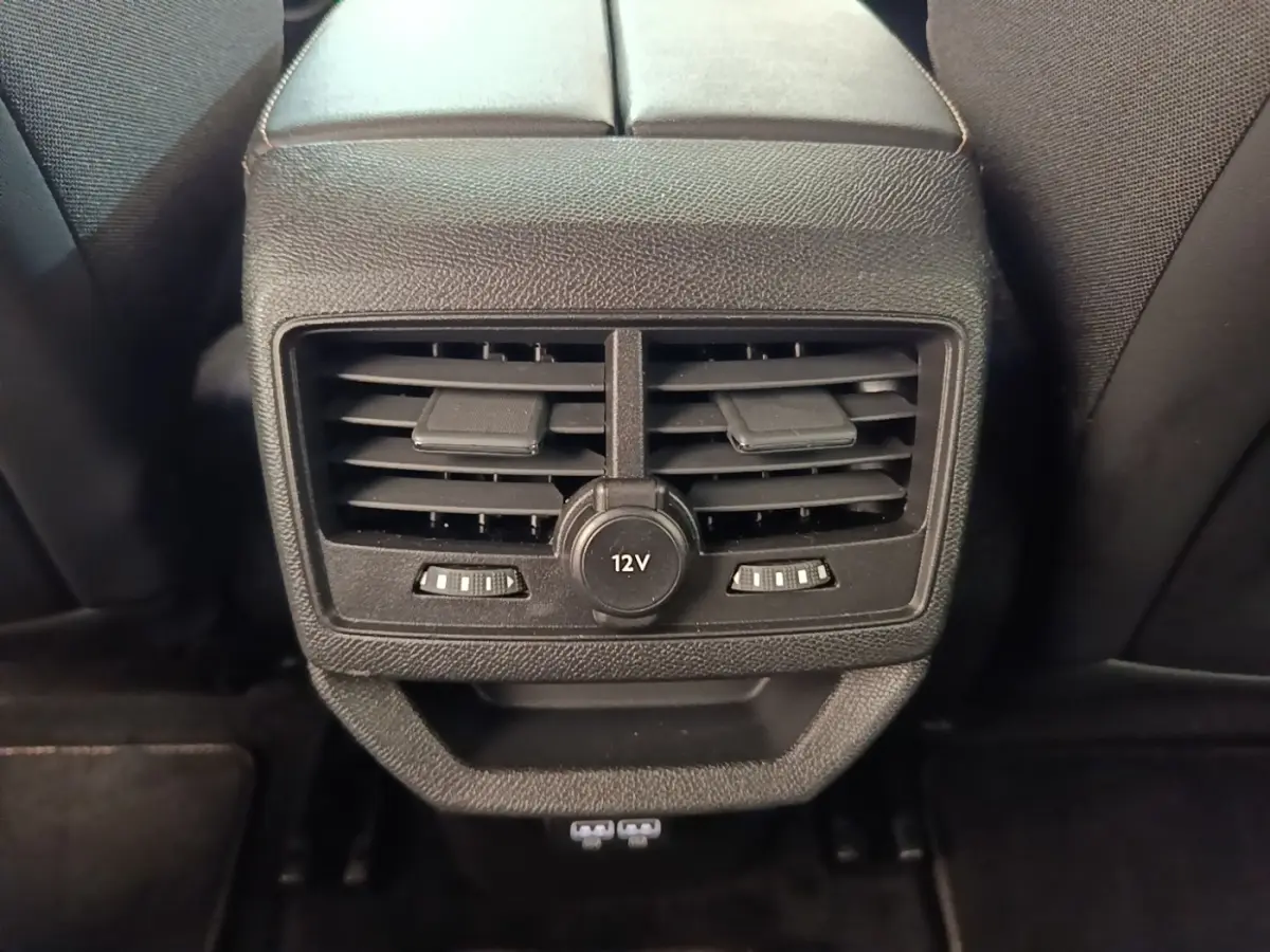 Vue rapprochée des aérateurs arrière noirs et prise 12V du Peugeot 3008 hybride rechargeable bleu 2022.