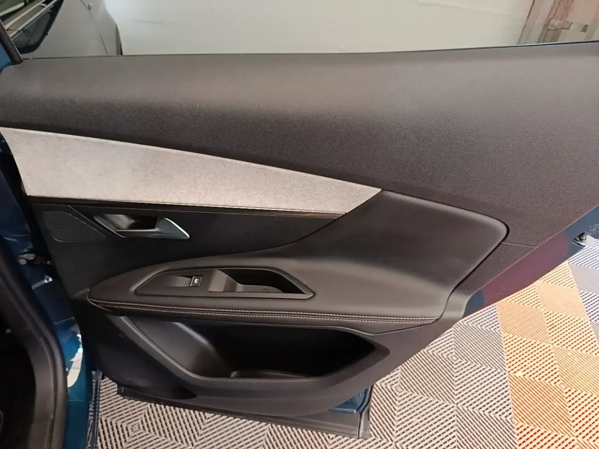 Vue intérieure de la porte avant gauche du Peugeot 3008 bleu, avec garniture noire et insert gris clair.