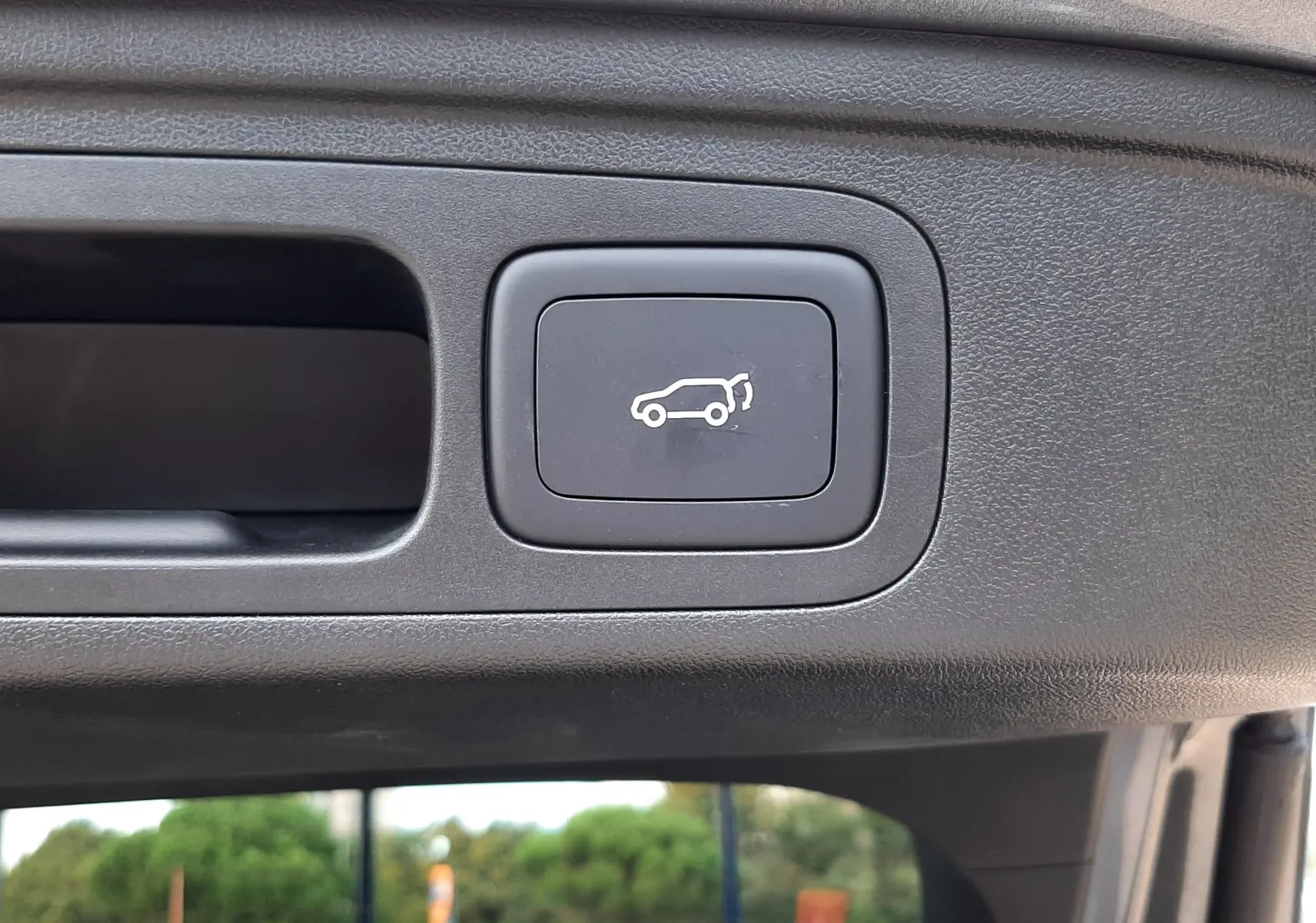 Bouton d'ouverture électrique du hayon sur le bord intérieur du coffre d'un MG MOTOR EHS Camden Grey.