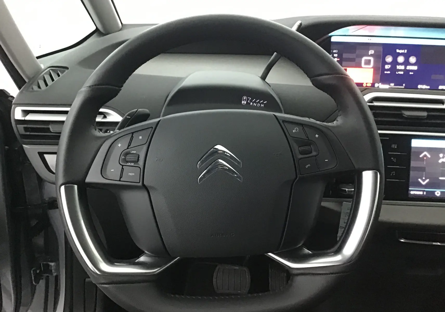 Vue rapprochée du volant cuir noir du Citroën Grand C4 Spacetourer 2021 avec commandes intégrées et tableau de bord numérique.