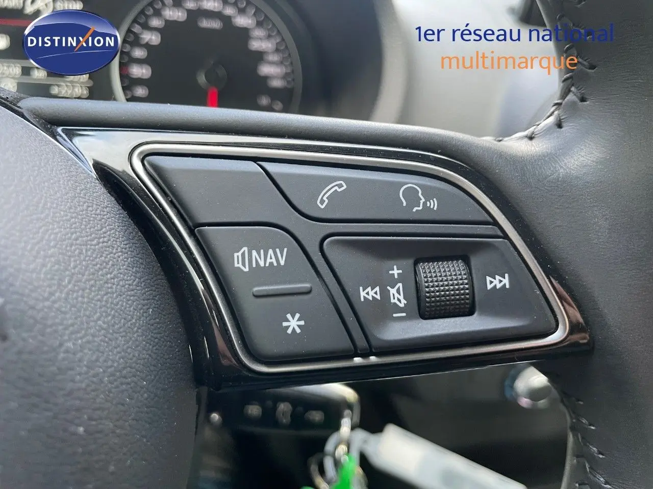 Gros plan sur les commandes du volant côté gauche de l'Audi A3 Sportback 35 TFSI bleu cosmos, avec boutons navigation et volume.